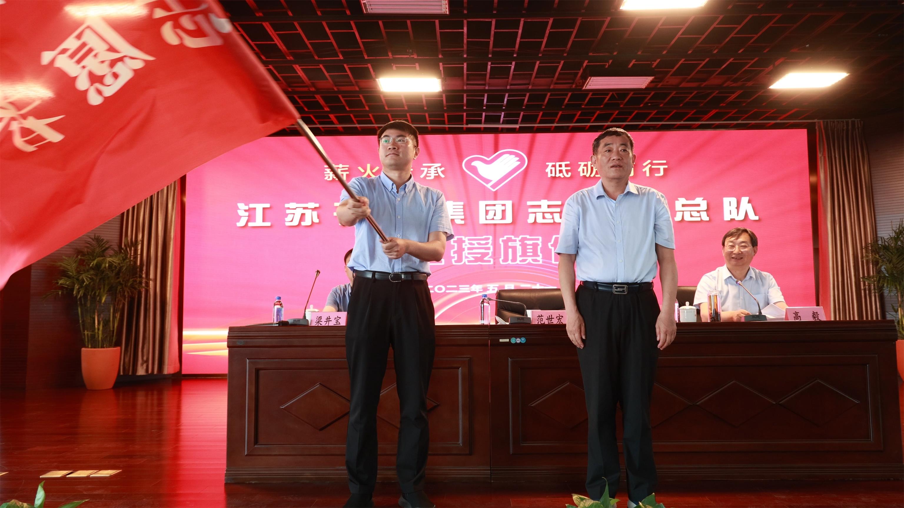 图1-3、范世宏董事长为邗建志愿者总队授旗.jpg